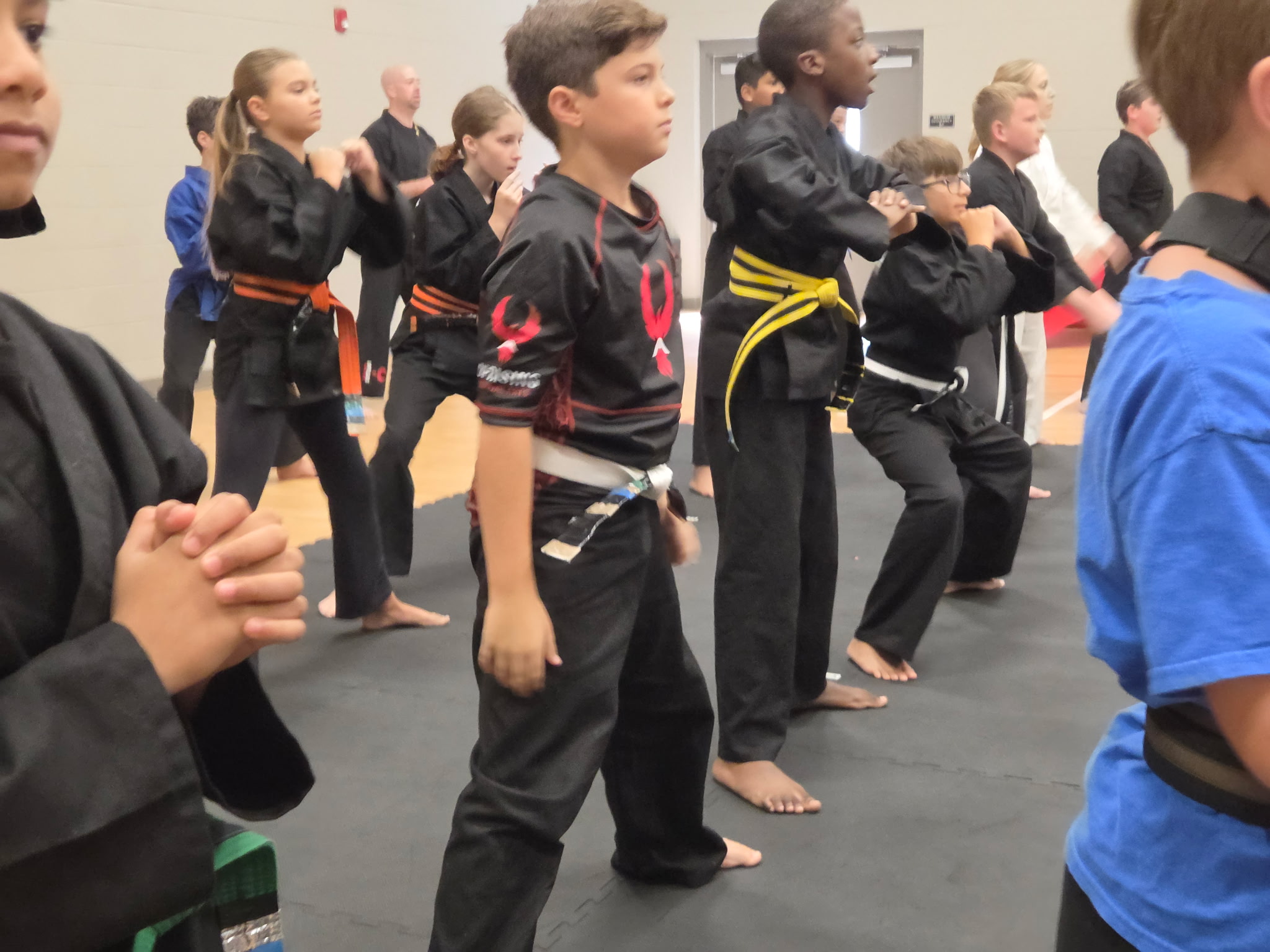 Uprising students at different belt levels practicing together as a class
